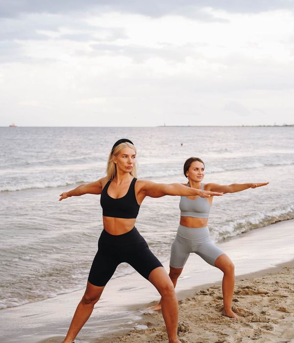 Person stretching outdoors during sunrise with a calm expression.